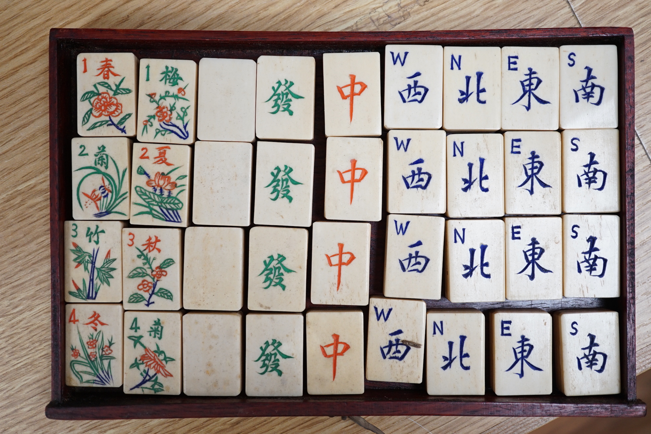 A Chinese Mah-Jong set in hardwood case with bone pieces